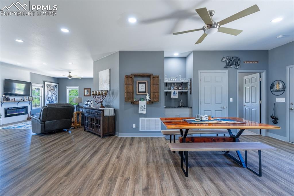 Image 6 of 41: Dining area with wood finished floors, recessed lighting, ceiling fan, and