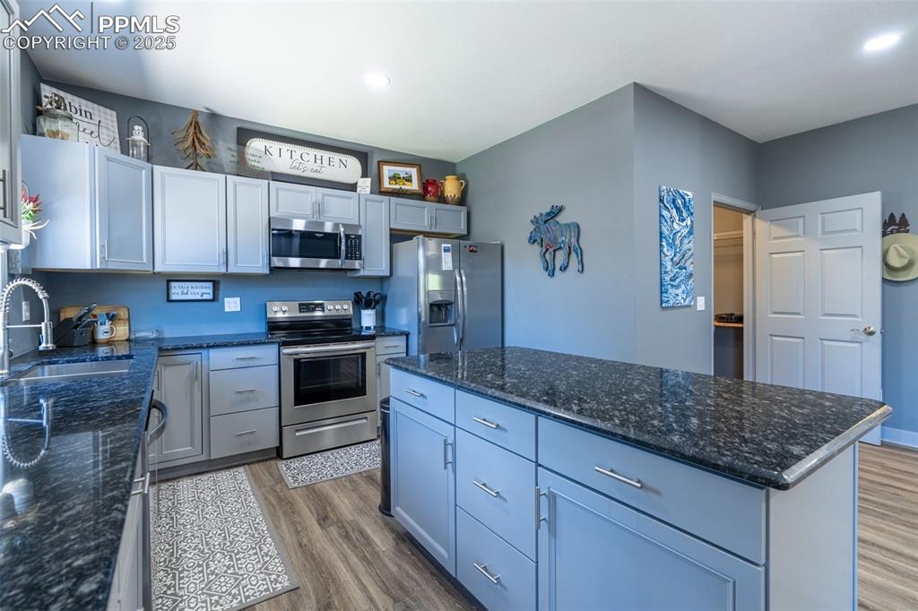 Image 9 of 41: Kitchen featuring appliances with stainless steel finishes, wood finished f