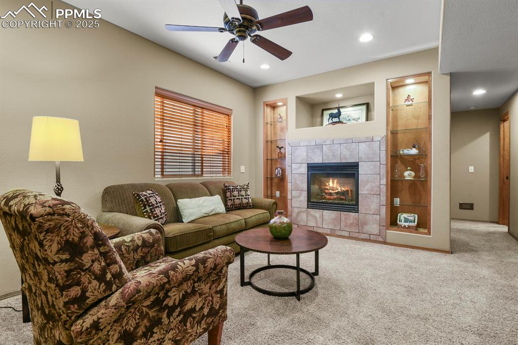 Image 30 of 49: Tiled gas fireplace with lighted shelving