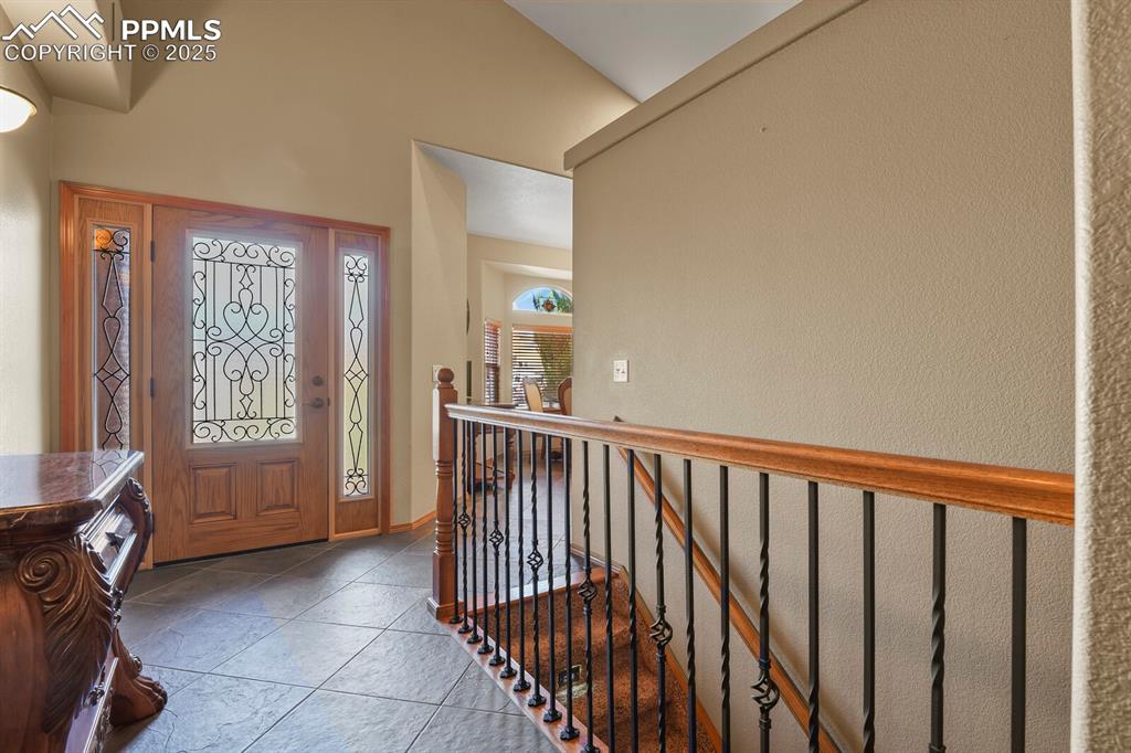 Image 9 of 49: Italian tile entry with rod iron railings to lower level