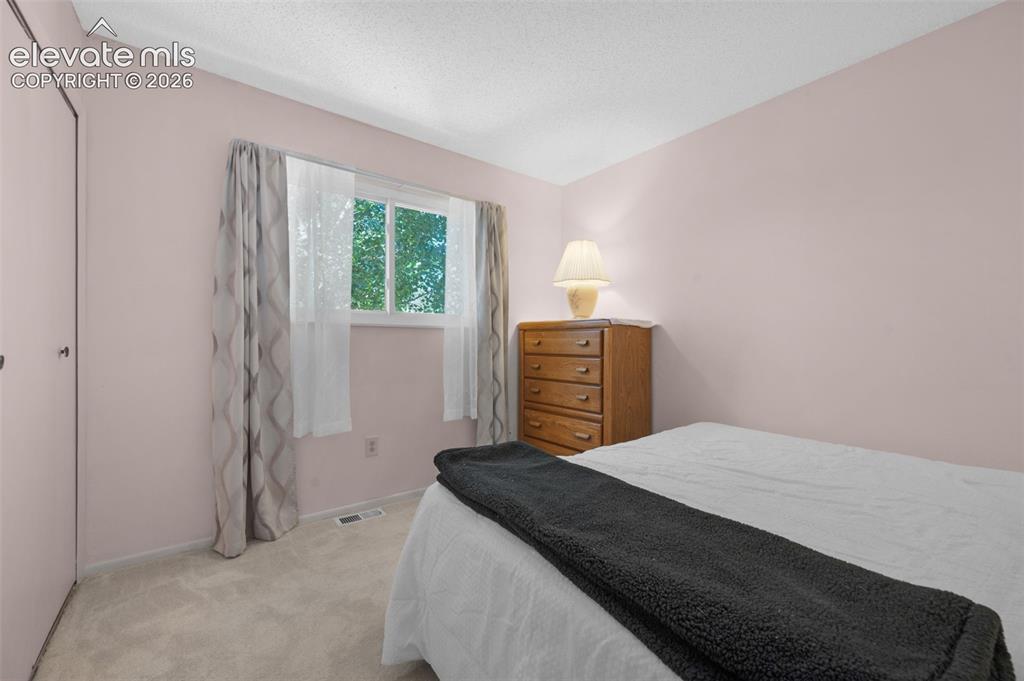 Image 10 of 25: Carpeted room with a double window and a closet featuring bi-fold doors