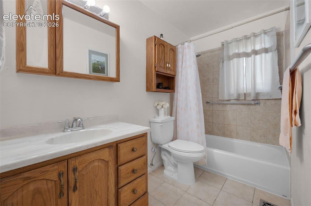 Image 9 of 25: Bathroom featuring a wood-finish vanity with an integrated sink and light-t