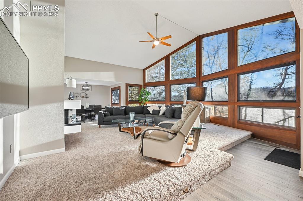 Image 15 of 48: Living area with high vaulted ceiling and a ceiling fan