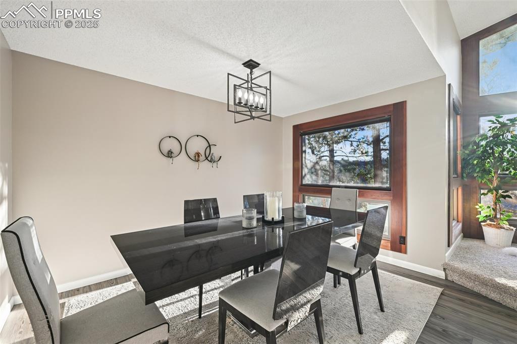 Image 18 of 48: Dining area featuring dark wood-type flooring, a textured ceiling, and a ch