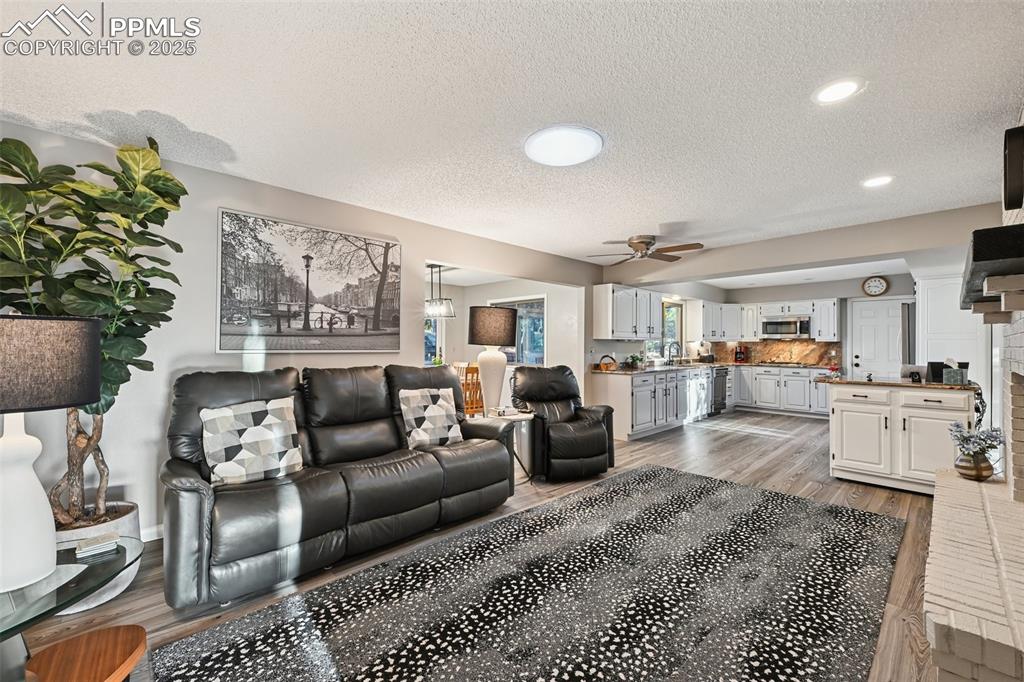 Image 20 of 48: Living room featuring light wood-style floors, a textured ceiling, a ceilin