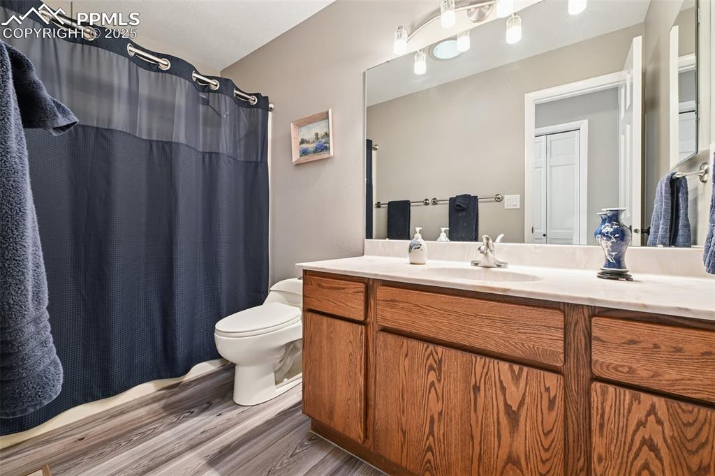 Image 30 of 48: Bathroom featuring a shower with curtain, dark wood finished floors, and va