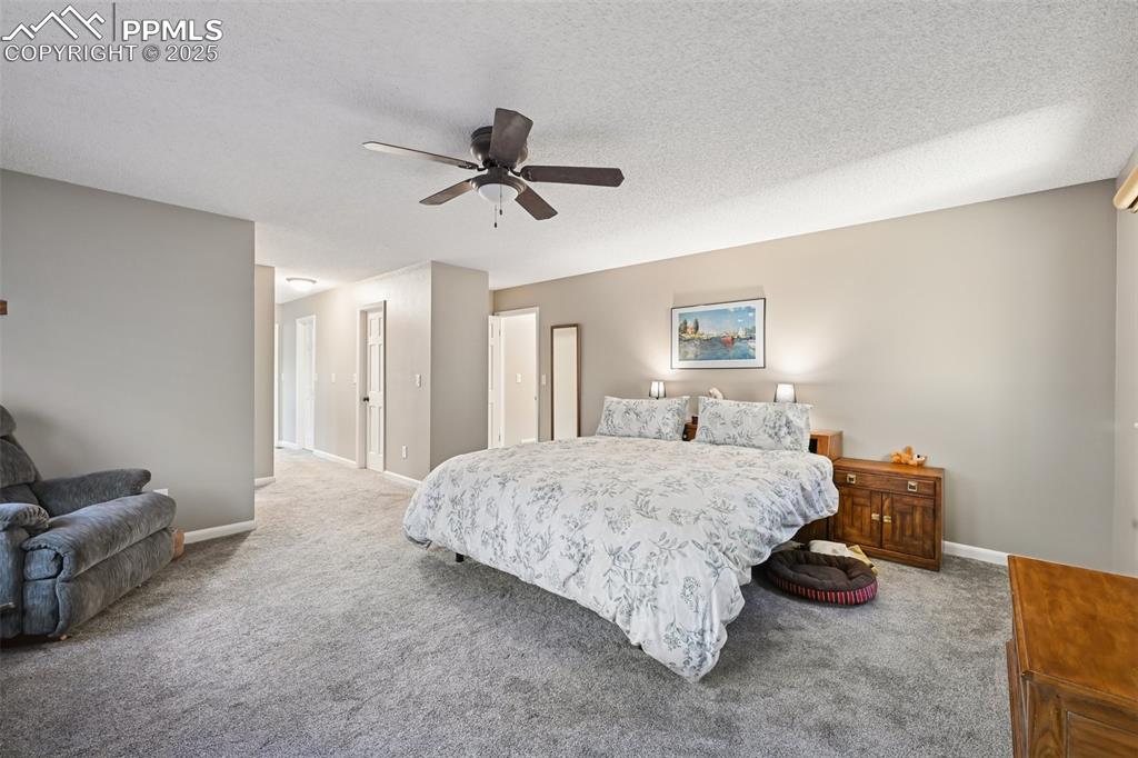 Image 32 of 48: Bedroom with carpet flooring, a textured ceiling, and ceiling fan