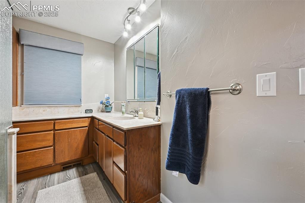 Image 34 of 48: Bathroom featuring vanity, dark wood finished floors, and a textured wall