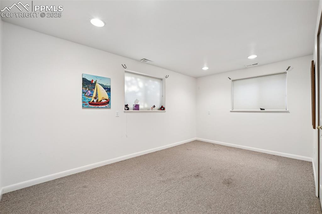 Image 37 of 48: Carpeted spare room with baseboards and recessed lighting