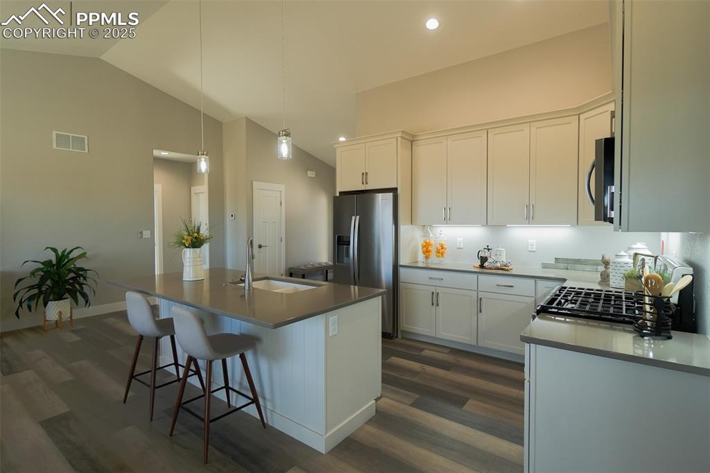 Image 11 of 47: Kitchen featuring white cabinetry, hardwood / LTV style floors, a kitchen i
