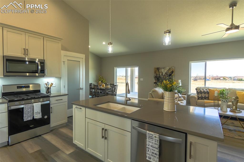 Image 12 of 47: Kitchen featuring LTV / wood-style flooring, an island with sink, ceiling f