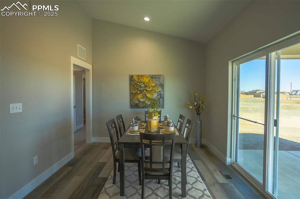 Image 16 of 47: Dining space with LTV/ wood-style floors and vaulted ceiling