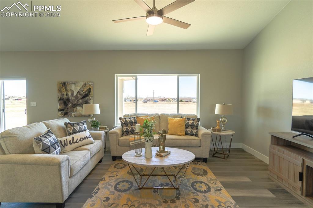 Image 19 of 47: Living room with ceiling fan and LTV/ wood-style floors