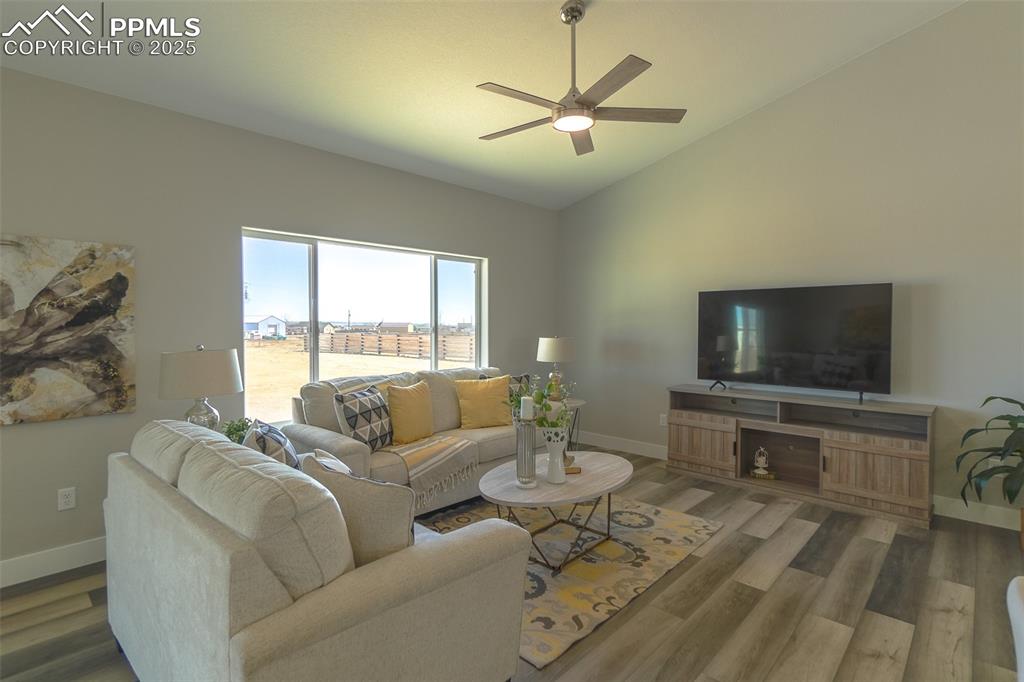 Image 20 of 47: Living room with lofted ceiling, ceiling fan, LTV wood-type flooring