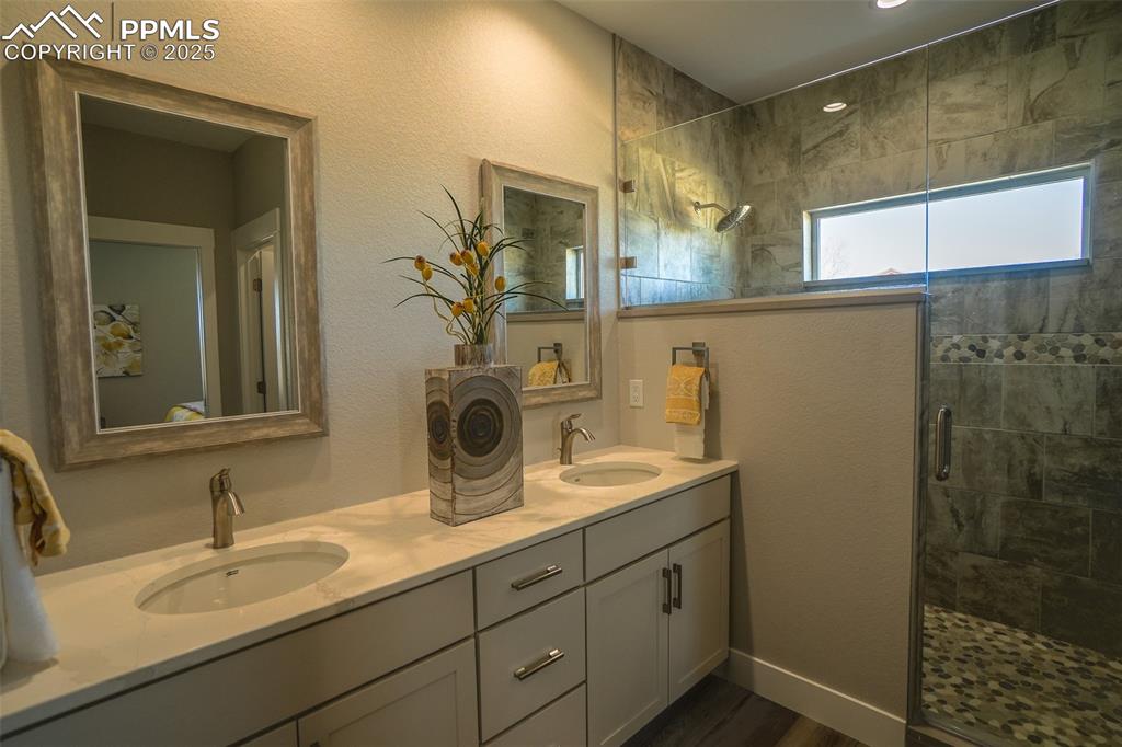 Image 26 of 47: Bathroom featuring dual vanity and an enclosed shower