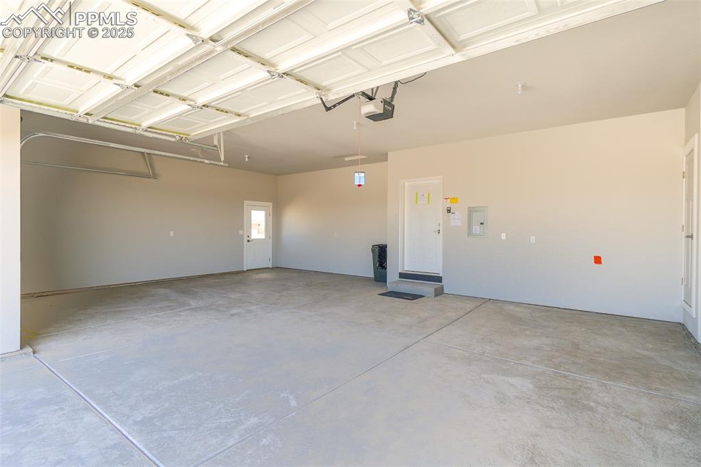 Image 43 of 47: Garage with electric panel and a garage door opener