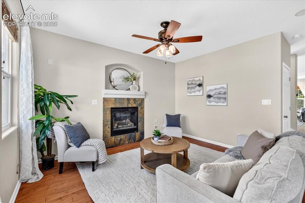 Image 11 of 28: Fireplace with stone surround and mantle, vaulted ceiling, ceiling fan with
