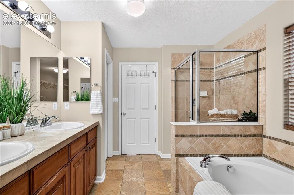 Image 15 of 28: Dual vanity with under-sink storage, tile flooring, glass-enclosed shower, 