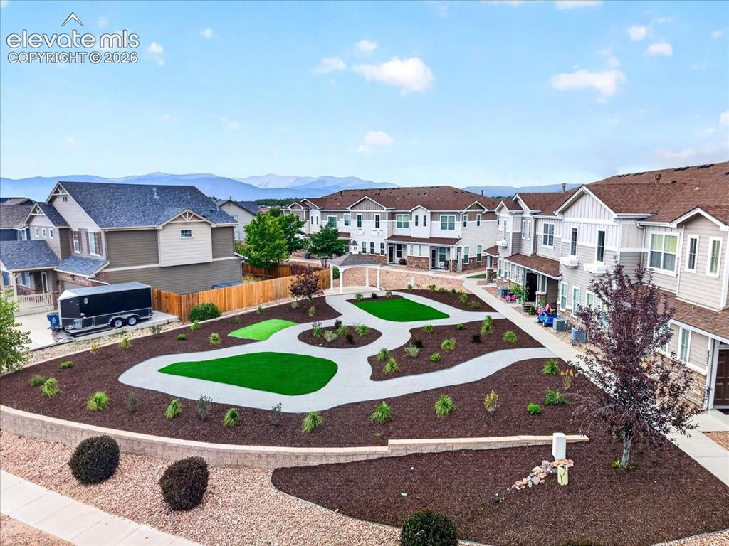 Image 28 of 28: Community green space featuring artificial turf areas, paved pathways, and 