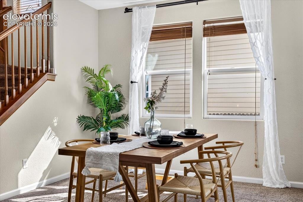Image 4 of 28: Window treatments with wood-finish blinds and sheer curtains