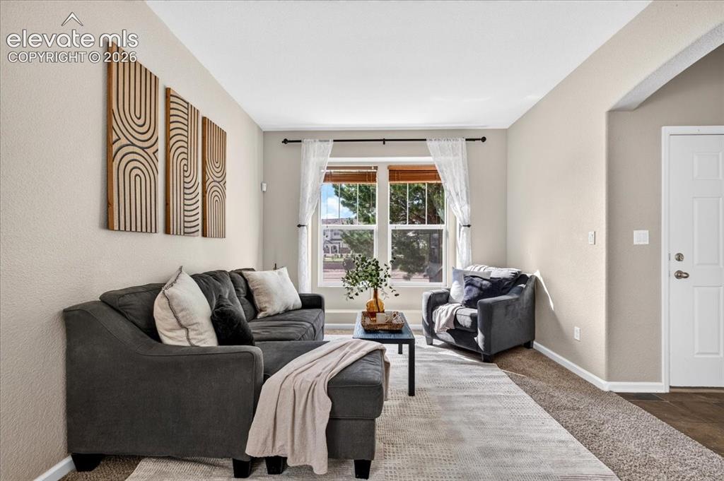 Image 5 of 28: Bright living area with large windows, neutral wall tones, and contrasting 