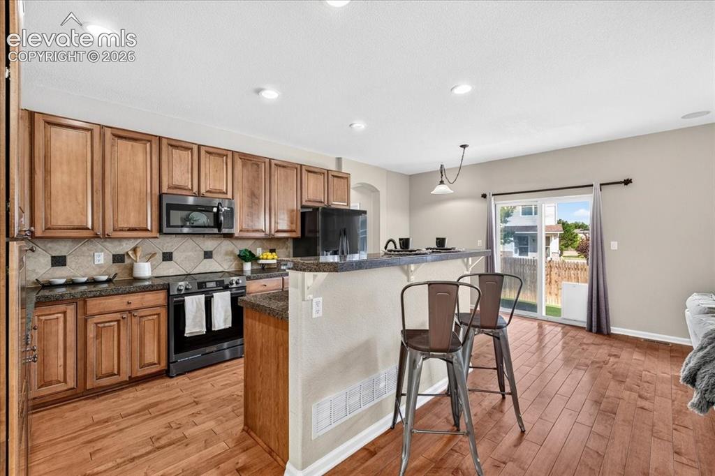 Image 7 of 28: Hardwood-finish flooring, recessed lighting, and a kitchen featuring wood c