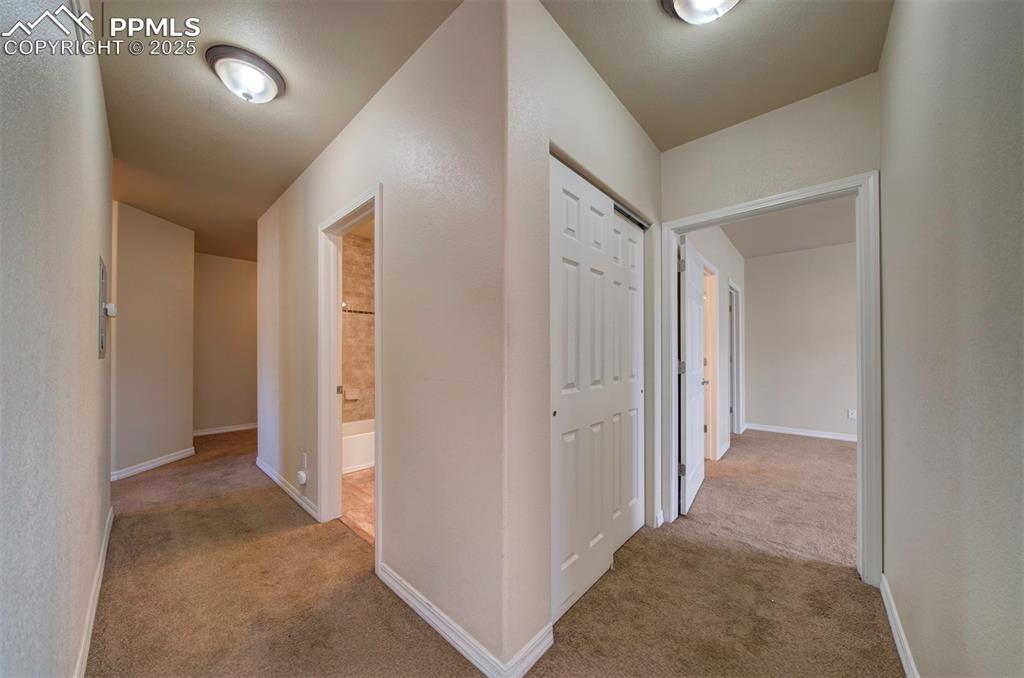 Image 13 of 36: Hallway off livingroom facing shared bath, pantry/linen storage and entranc