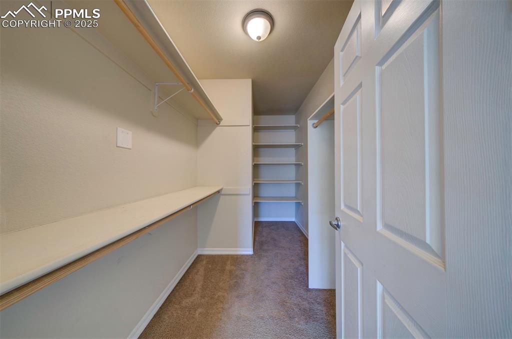 Image 20 of 36: Walk in closet with built in shelves and organizers