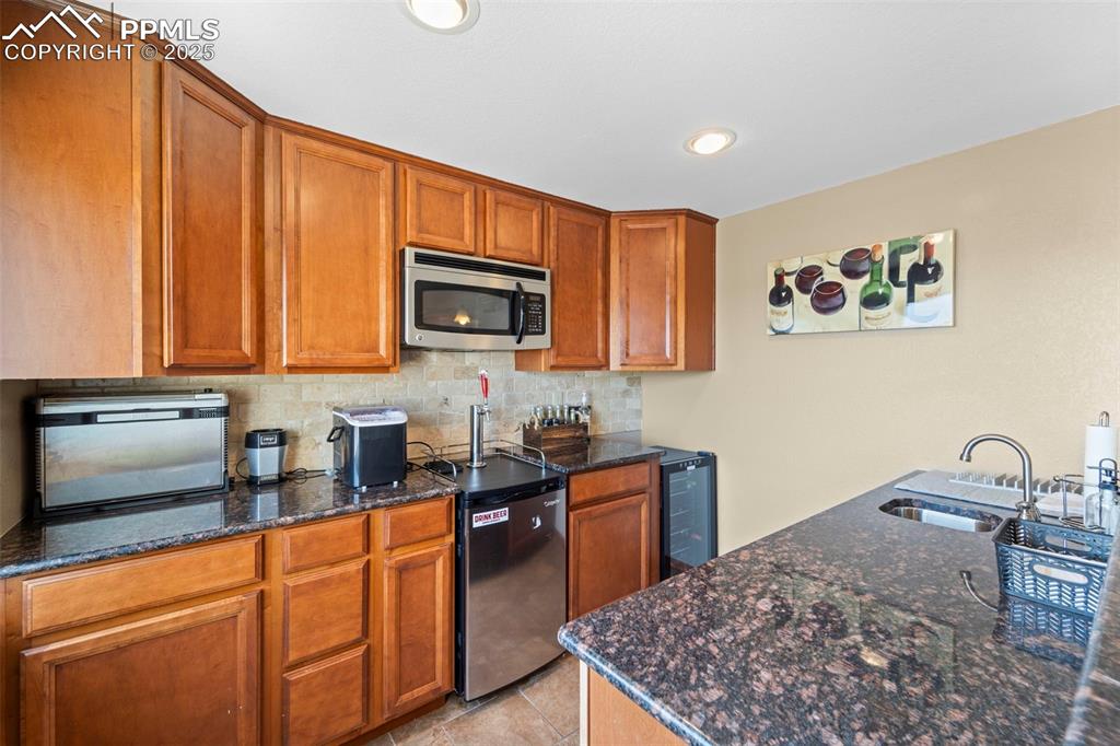 Image 30 of 41: Basement kitchen with sink, dishwasher, microwave, kegorator and wine fridg