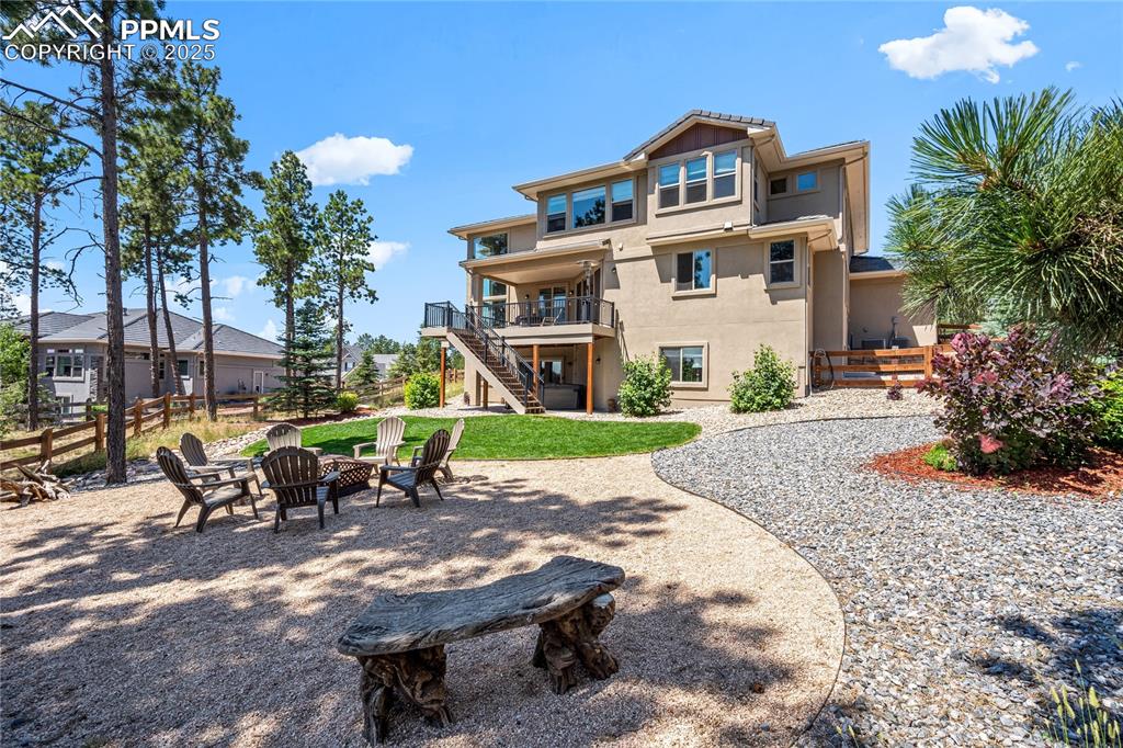 Image 42 of 46: Rear view of house featuring a patio area, a fire pit, stairway, and stucco