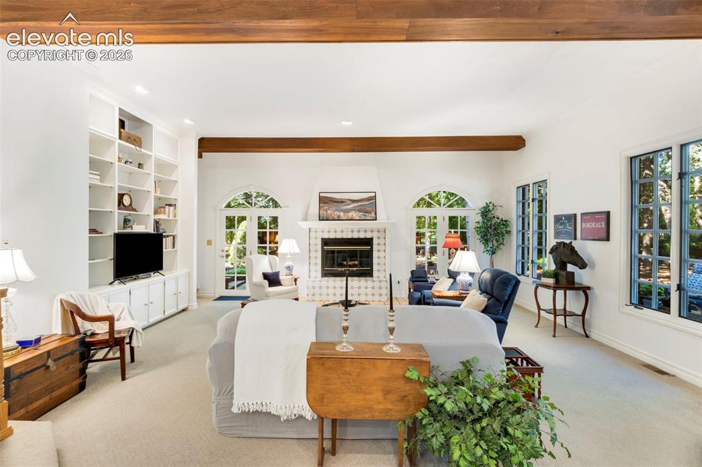 Image 11 of 50: Step down Family room with fireplace and builtins