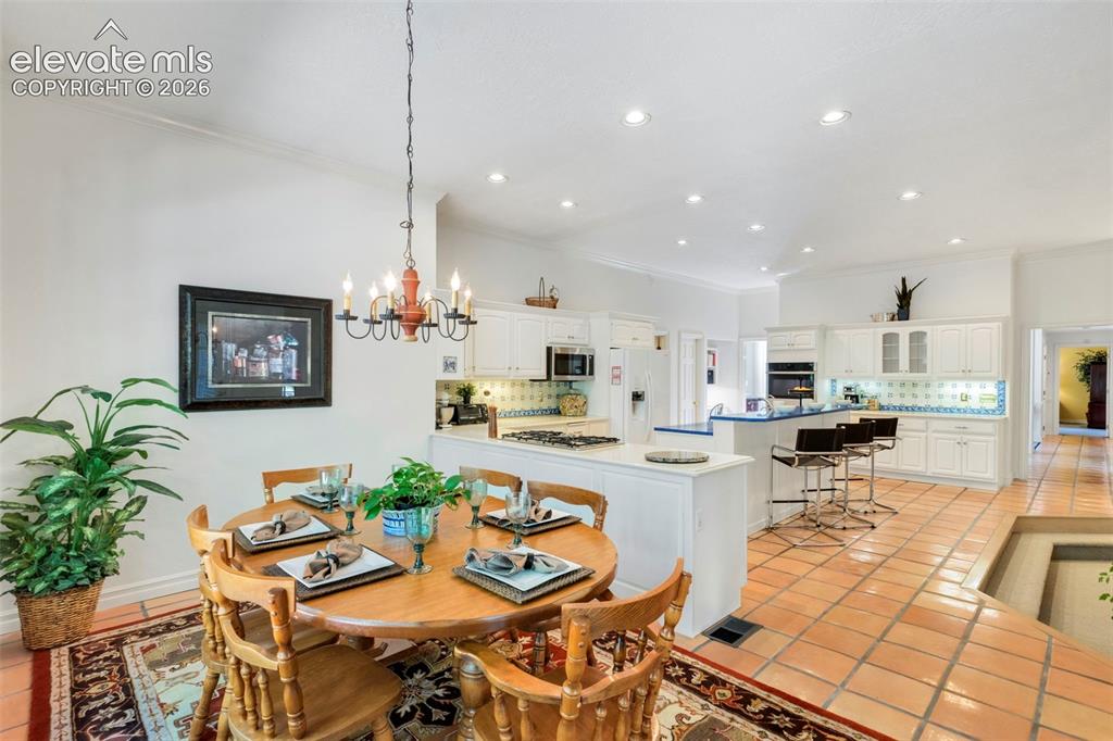 Image 19 of 50: Casual dining area open to kitchena dn stepdown family room