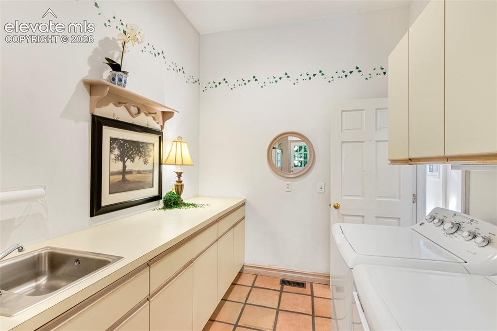 Image 21 of 50: Laundry, with 1/2 bath, door to garage and workshop