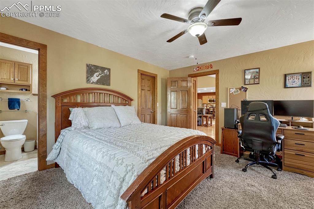 Image 18 of 30: This bedroom offers neutral carpet, walk-in closet, ceiling fan and 3/4 bat