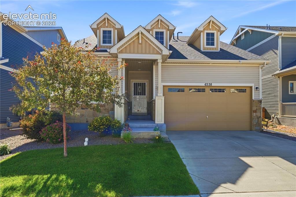 Caption: Contemporary residence featuring a two-car garage, concrete driveway, and a welcoming front porch