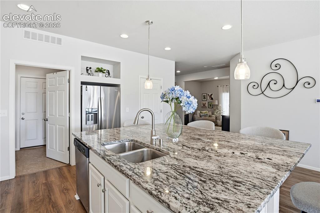 Image 10 of 47: Kitchen island featuring a double basin stainless steel sink, a high-arc fa