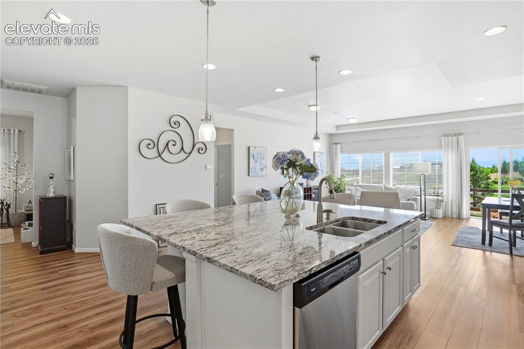 Image 11 of 47: Kitchen island featuring a double basin sink, stainless steel dishwasher, a