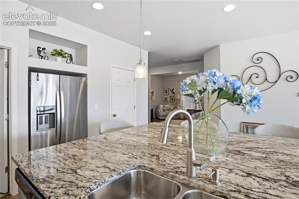 Image 13 of 47: Spacious kitchen island featuring a granite countertop, dual stainless stee