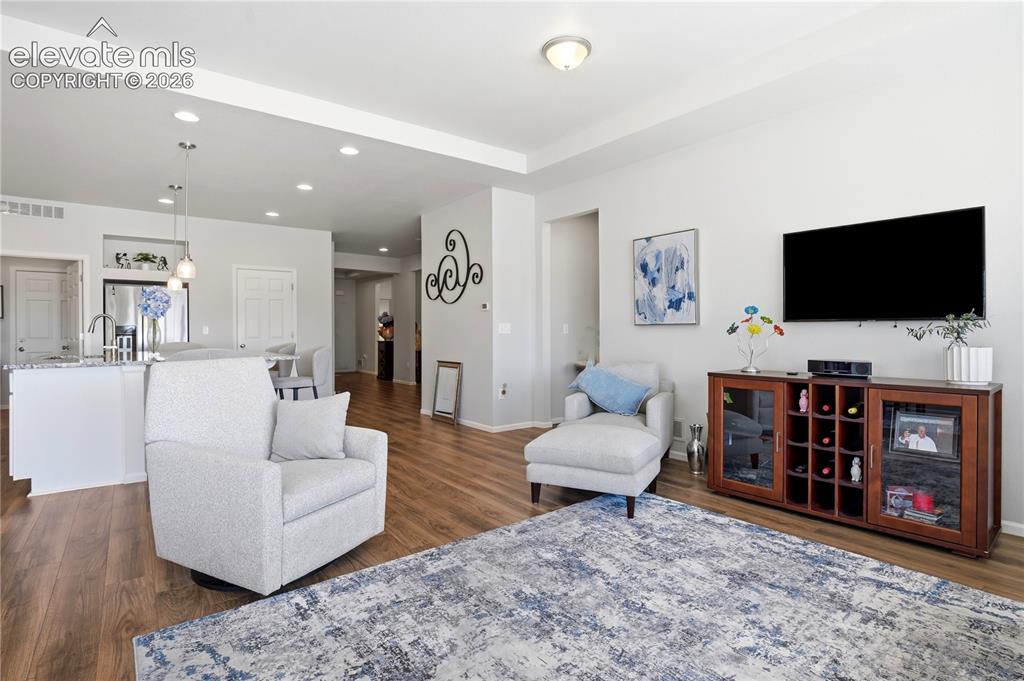 Image 20 of 47: Open-concept living area featuring wood-finish flooring, recessed lighting,