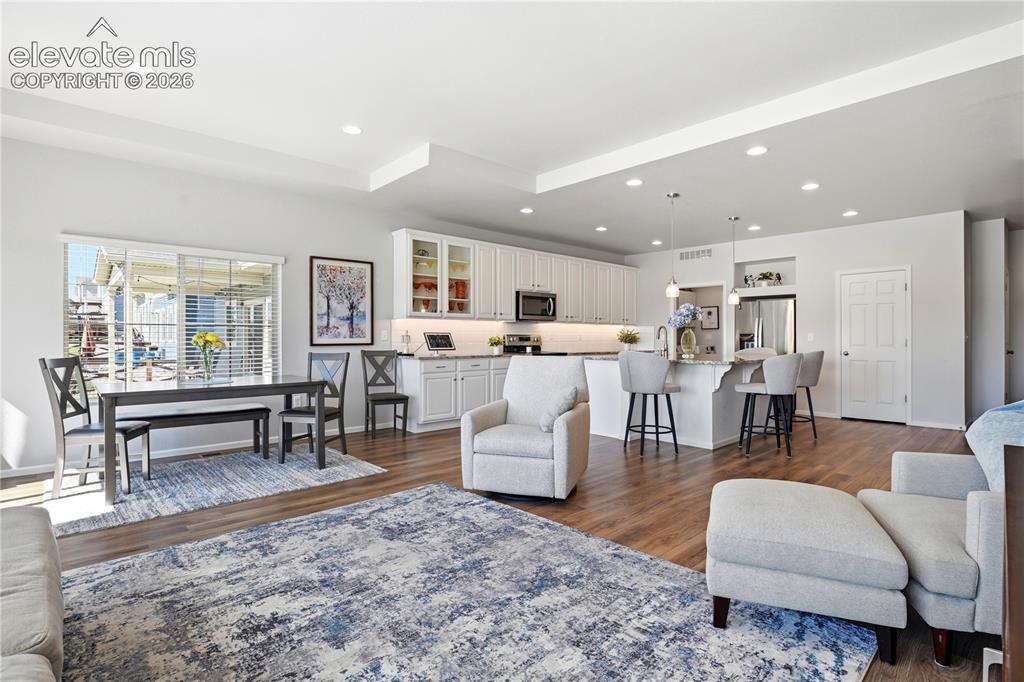 Image 21 of 47: Open-concept living space featuring wood-finish flooring, recessed lighting