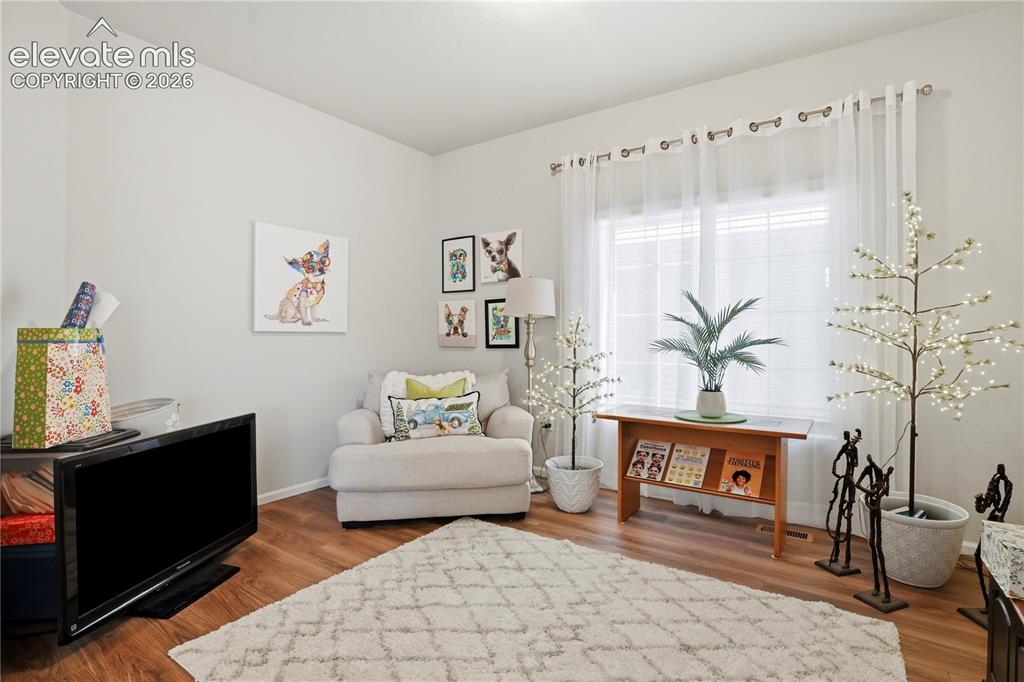 Image 3 of 47: Living area featuring wood-finish flooring, a large window with sheer white