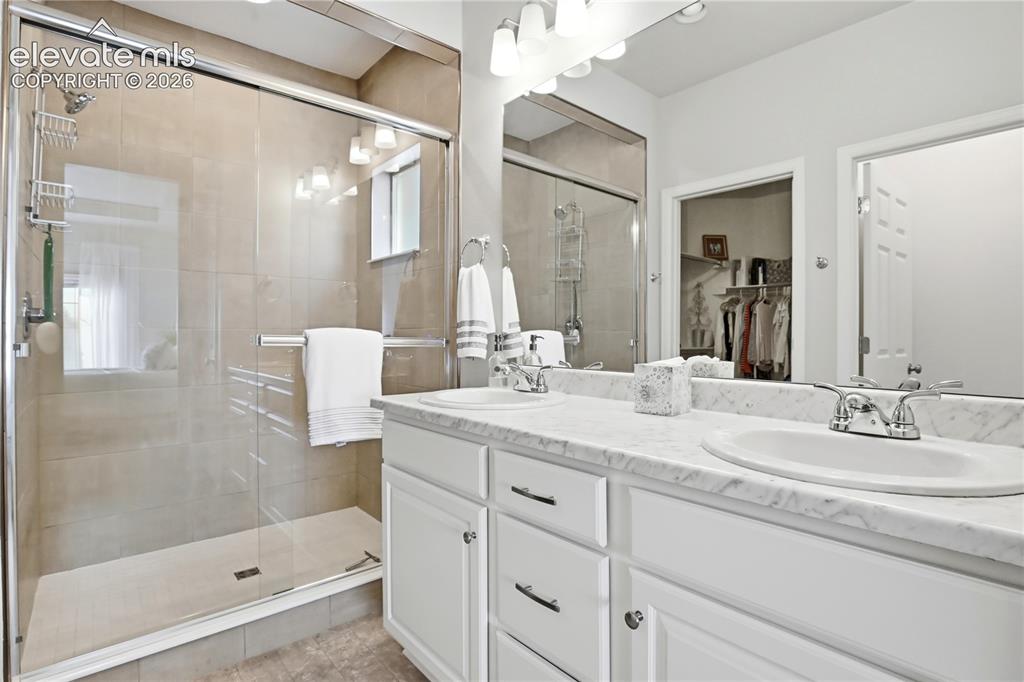 Image 31 of 47: Bathroom featuring a spacious walk-in shower with tile surround and glass e