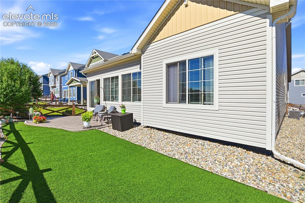 Image 37 of 47: Expansive green lawn with a paver patio area