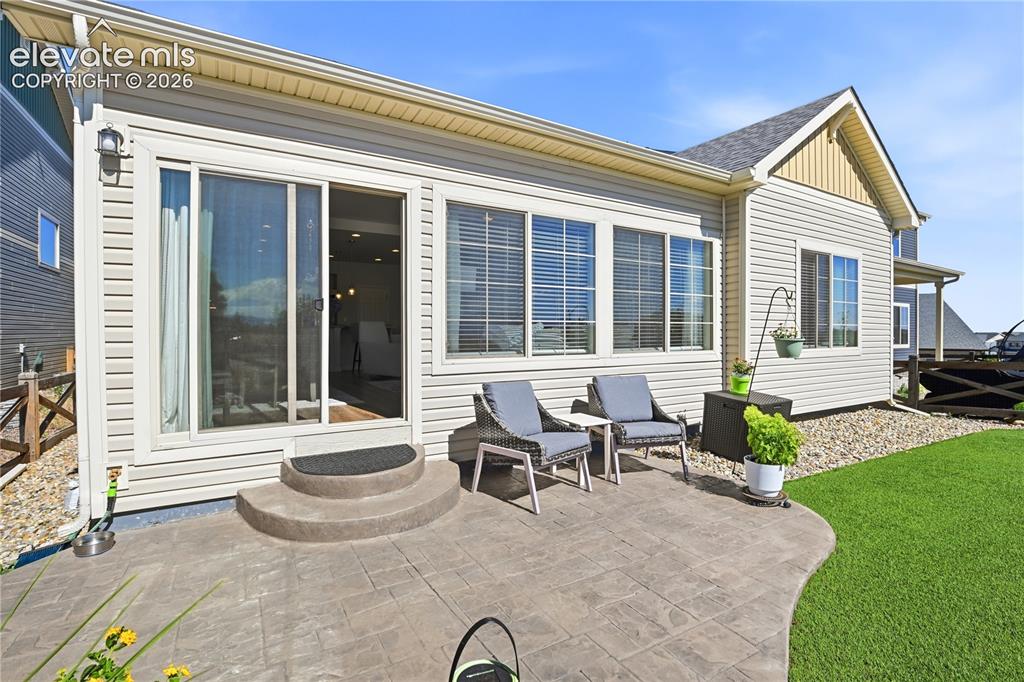 Image 38 of 47: Stamped concrete patio with curved edges, featuring a sliding glass door en