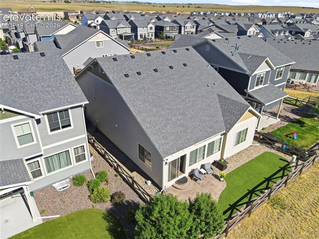 Image 45 of 47: Rear exterior featuring a concrete patio, artificial turf lawn, and wooden 