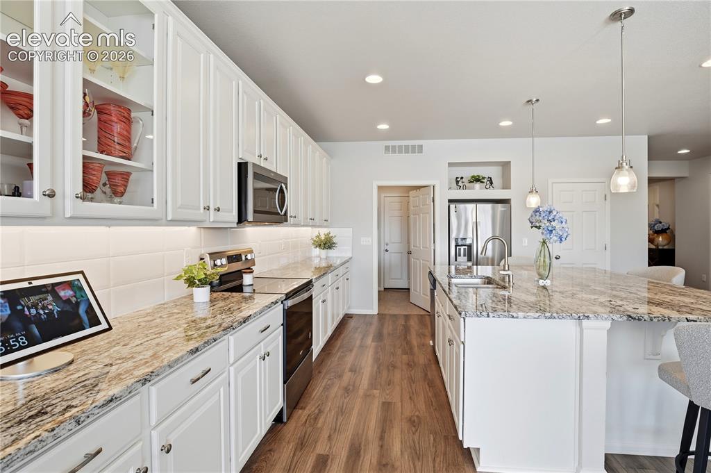 Image 8 of 47: Gourmet kitchen featuring a large central island with seating, stainless st
