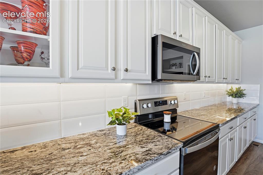 Image 9 of 47: Kitchen featuring white cabinetry, granite countertops, stainless steel app
