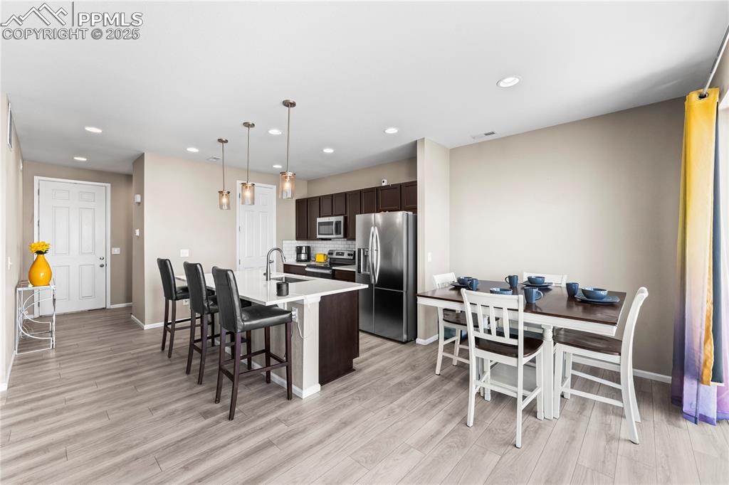 Image 11 of 32: Kitchen with dark brown cabinetry, appliances with stainless steel finishes