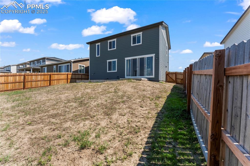 Image 28 of 32: Rear view of property with a fenced backyard