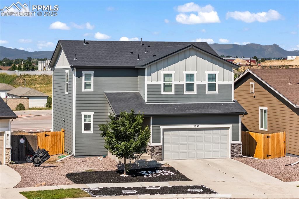 Image 4 of 32: Rear view of house featuring a mountain view, board and batten siding, roof